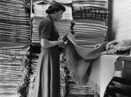 A woman checking woollen blankets, Dinas...