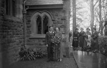 Photograph of a bridal couple outside a church,...