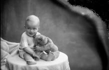 Photograph of the Price baby with a teddy bear,...