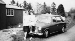 Two women in front of car