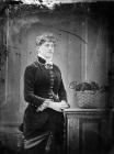 woman standing next to a basket of flowers