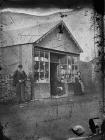 man, child and woman standing outside a shop