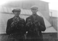 Men holding fox cubs