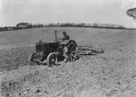 Man harrowing with tractor and disk harrow
