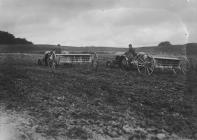 Men on tractors pulling agricultural implements