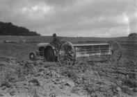 Man on tractor pulling agricultural implement
