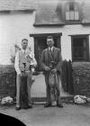 Two men with golf clubs, one holding a trophy,...