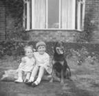 Children with dog in front of house