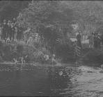 People and dogs near river, circa 1930s