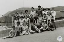 Criw o blant sy'n aros yn Llangrannog