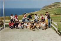 Criw o blant sy'n aros yn Llangrannog