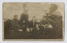 Group of four soldiers relaxing outside a tent,...