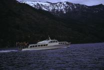 Pleasure boat on water surrounded by mountains