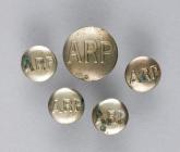 Five metal Air Raid Precautions (ARP) uniform...