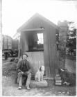  One man and his dog by railway work shed c.1900