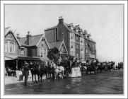 Row of carriages with passengers outside Craig...