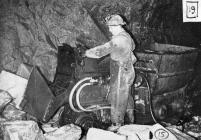 Miner loading chunks of ore inside the mine