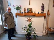 Harry Comley standing by his sculpture The Scroll