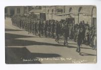 Postcard image of a procession passing the...